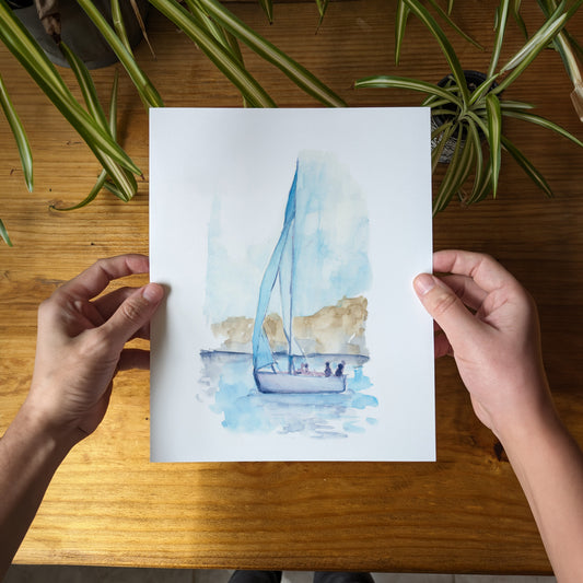 a person holding a card with a sailboat on it
