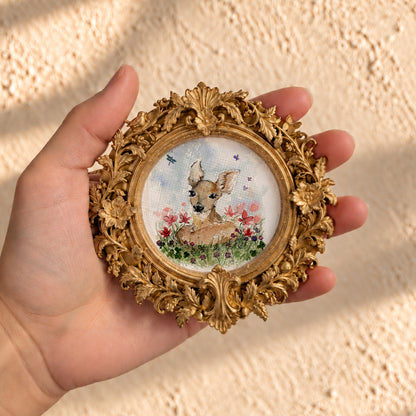 Baby fawn watercolor print in round gold baroque frame, held in hand